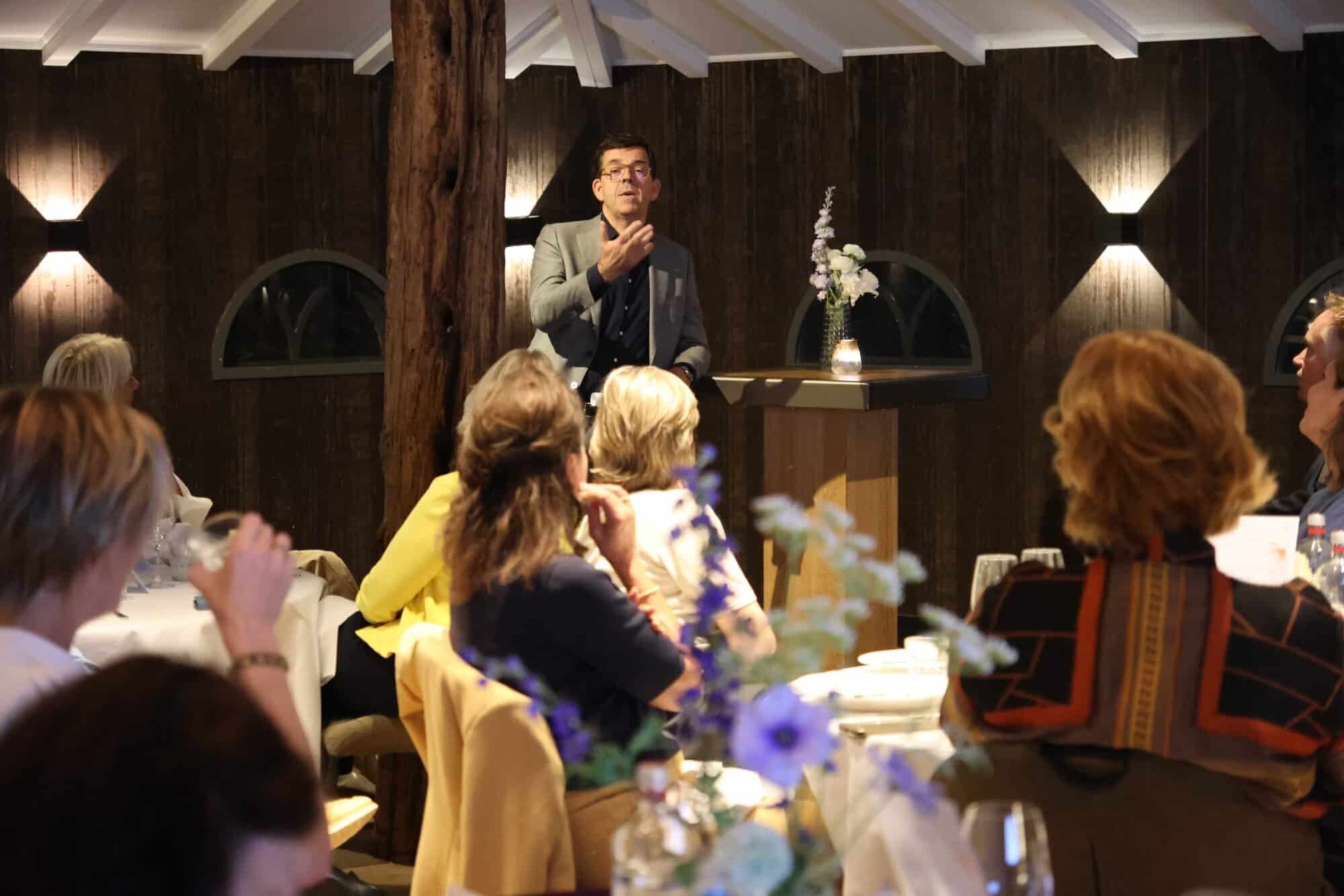 Professionele spreker tijdens bijeenkomst in sfeervolle zaal in Utrechtzorg.