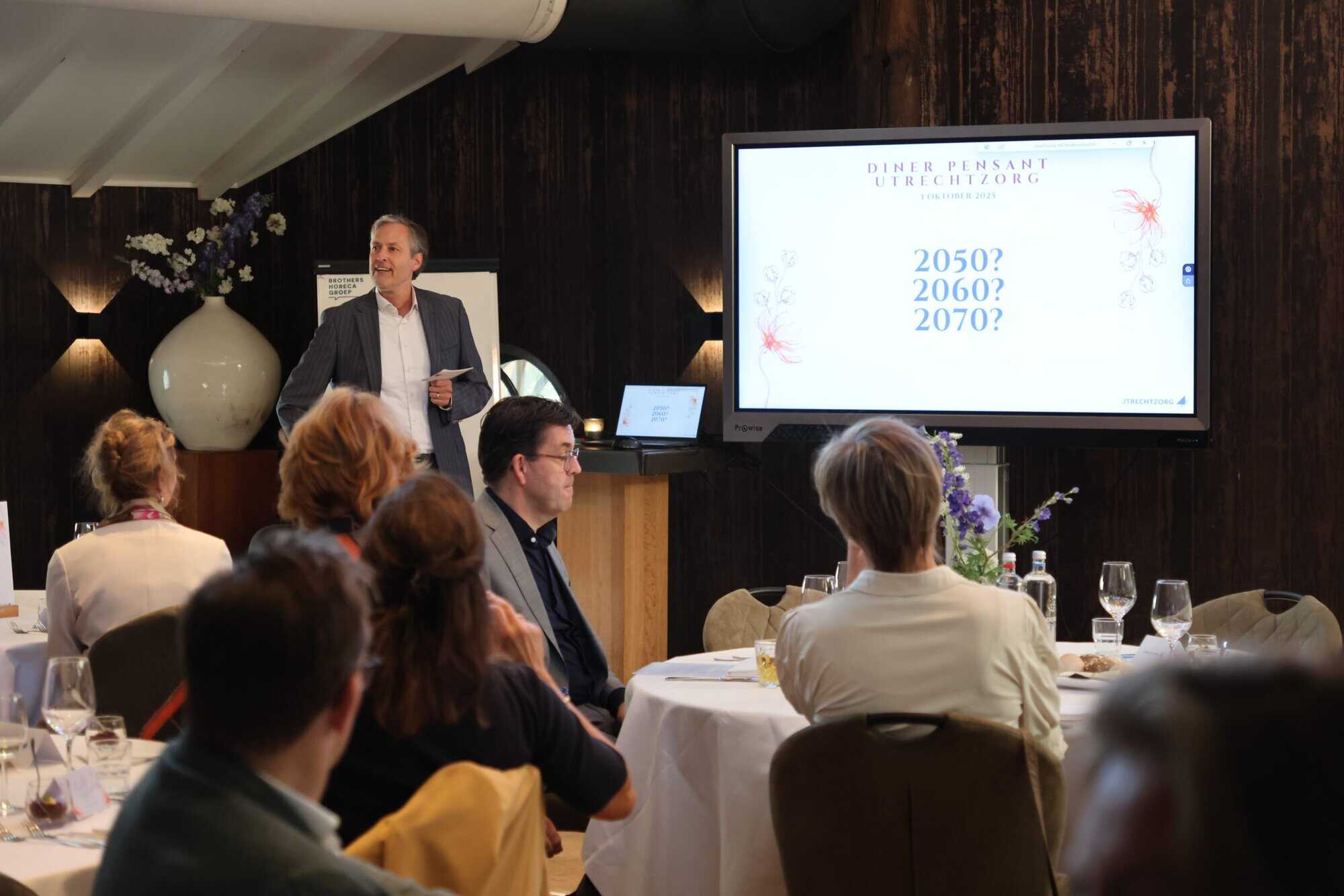Zorgbijeenkomst Utrechtzorg met presentatie en deelnemers op conferentie.