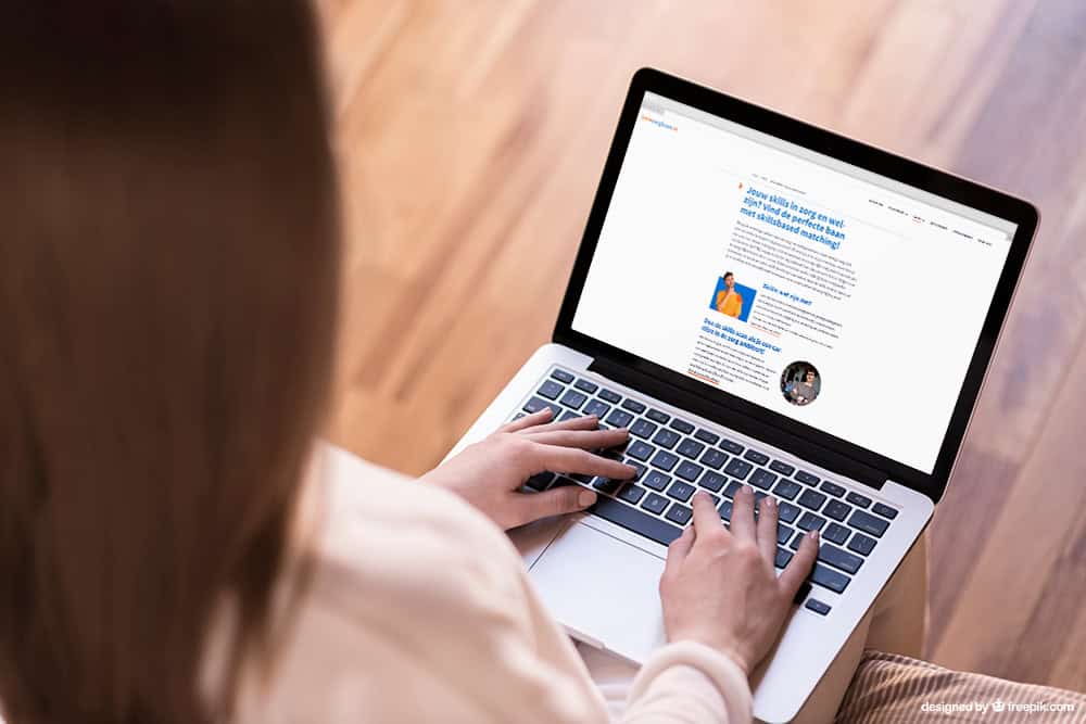 Vrouw zit op laptop en bekijkt de website jouwzorgbaan.nl.